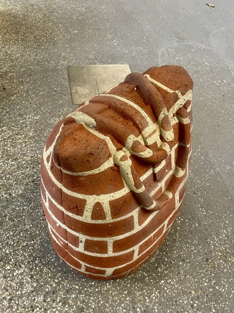 En skulptur av en brune steinstruktur med hvite mursteinlignende detaljer.